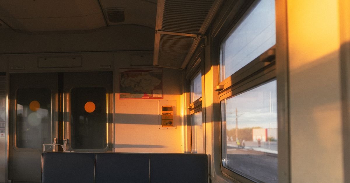 Empty train carriage in low evening sunlight, the commute home with emotional exhaustion