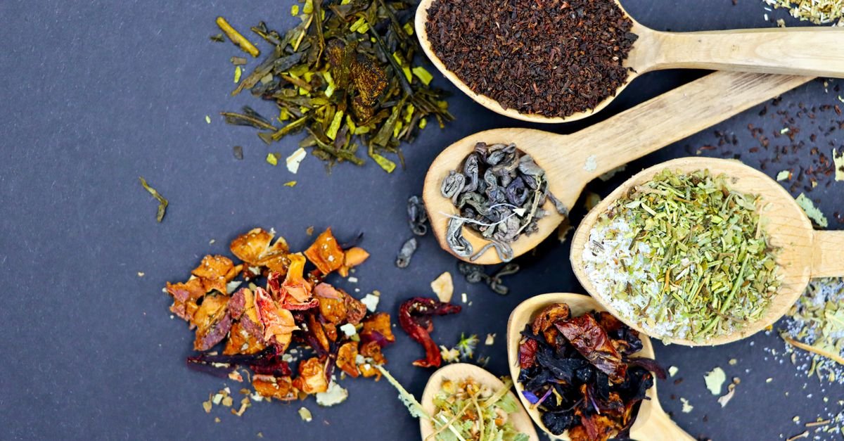 Loose leaf tea on wooden spoons, showing how little theanine one cup delivers for green tea brain fog