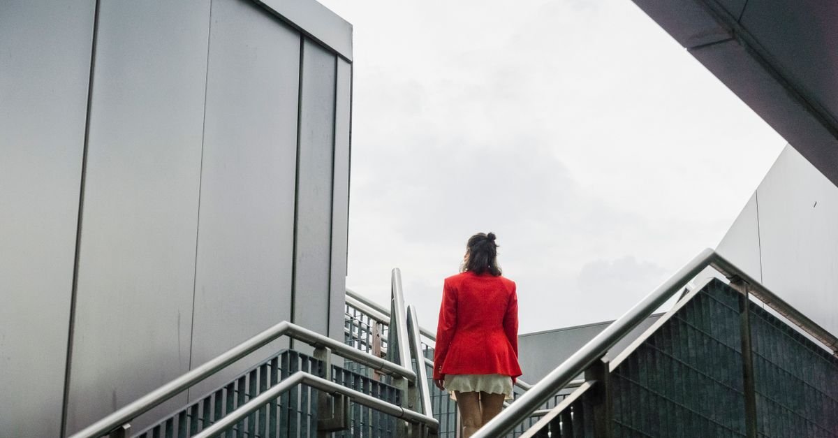 A woman climbing outdoor stairs, where breathlessness can sit alongside low iron brain fog
