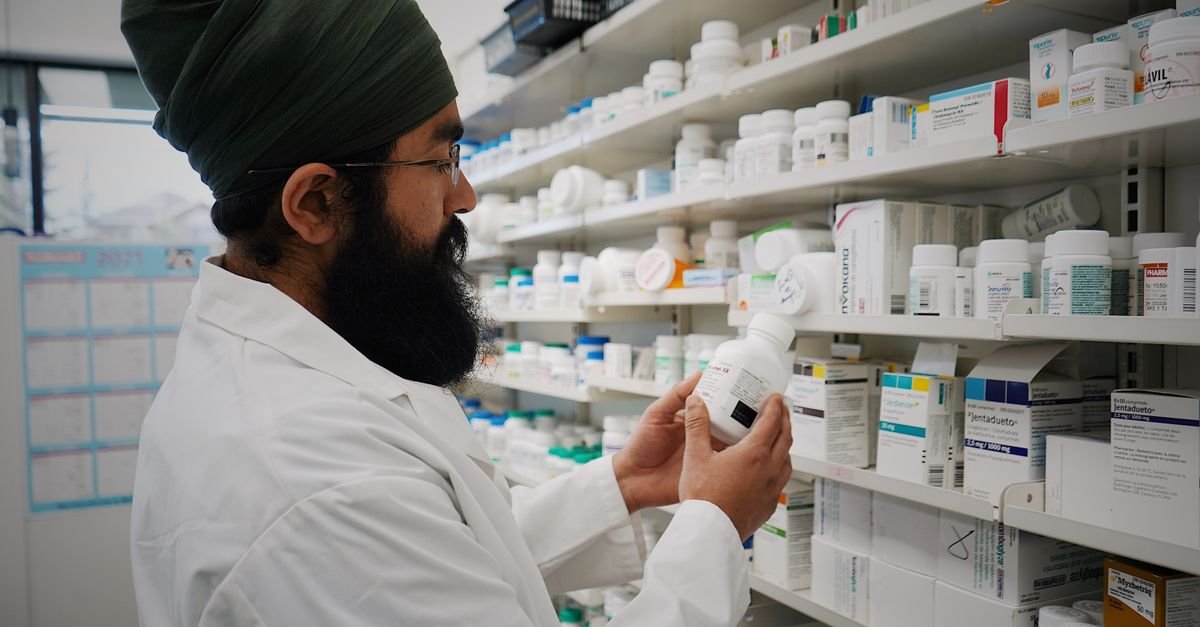 A pharmacist restocking shelves, a reminder that low iron brain fog is not solved by picking a box